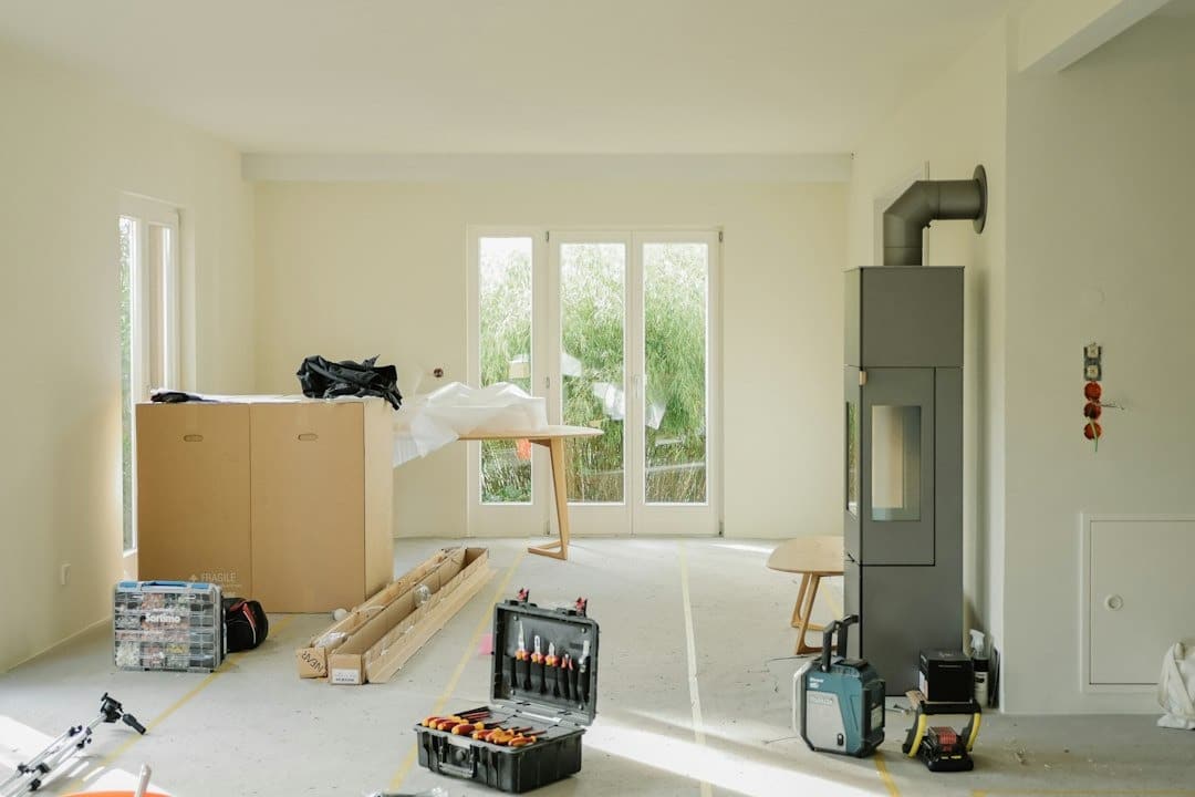 Renovating an empty room with tools on a concrete floor.